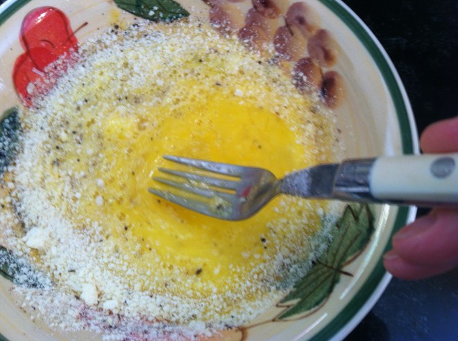 whisking egg with parmigiano